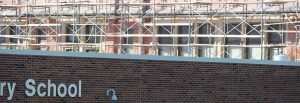 picture of school with scaffolding set up on far wall