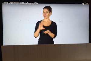 Woman on screen signing with lower 1/4 of screen covered by paper - hiding the captions